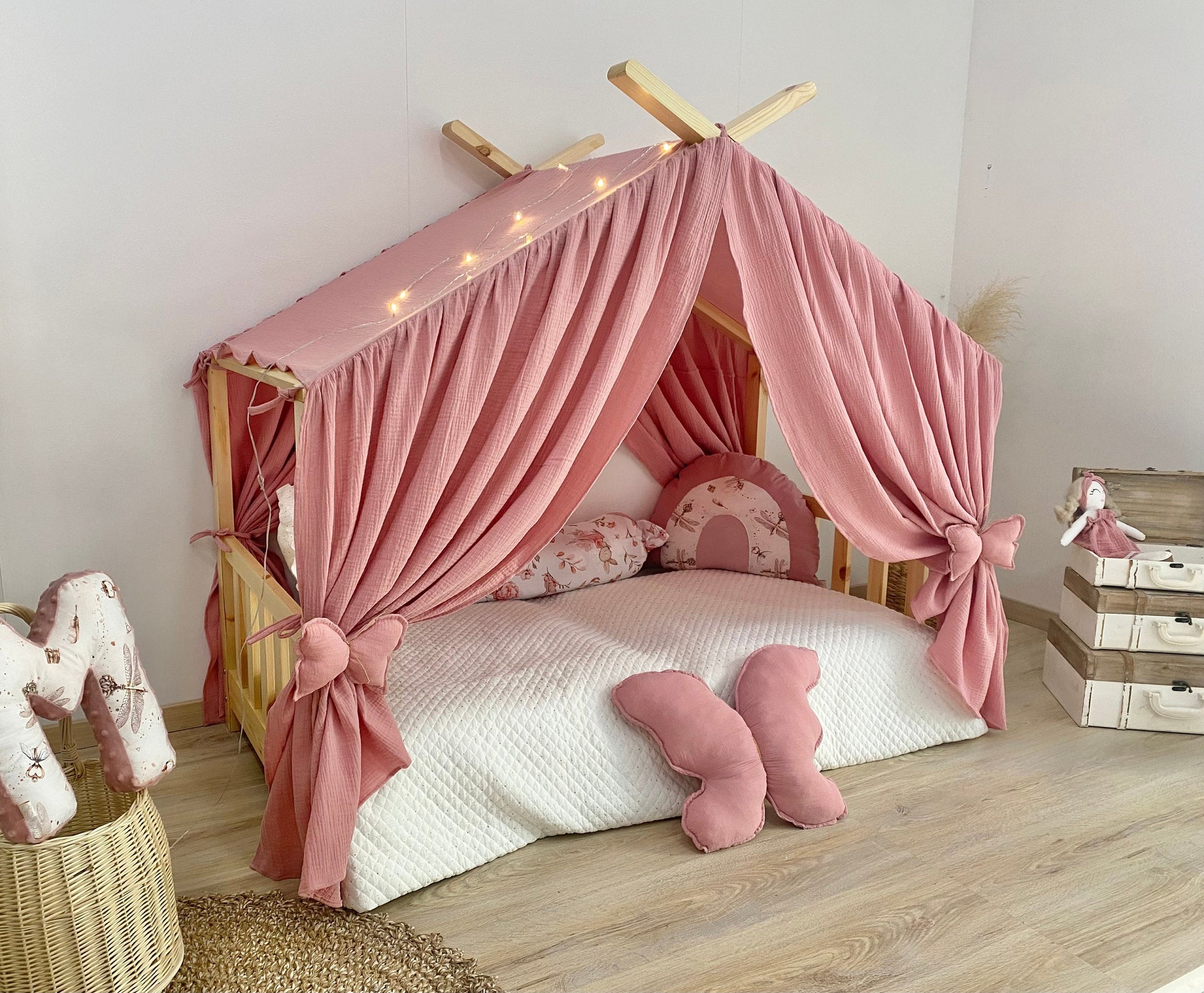 Blush pink canopy over Montessori floor bed