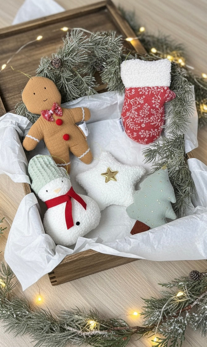 Decorative Christmas scene with gingerbread man, snowman, and tree on a wooden tray with greenery and lights.