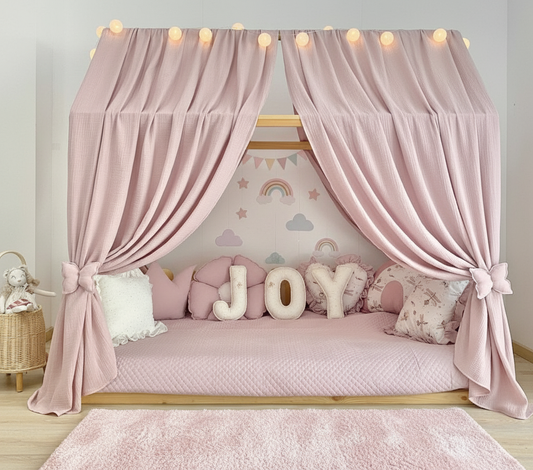 Dusty rose muslin canopy over children’s floor bed